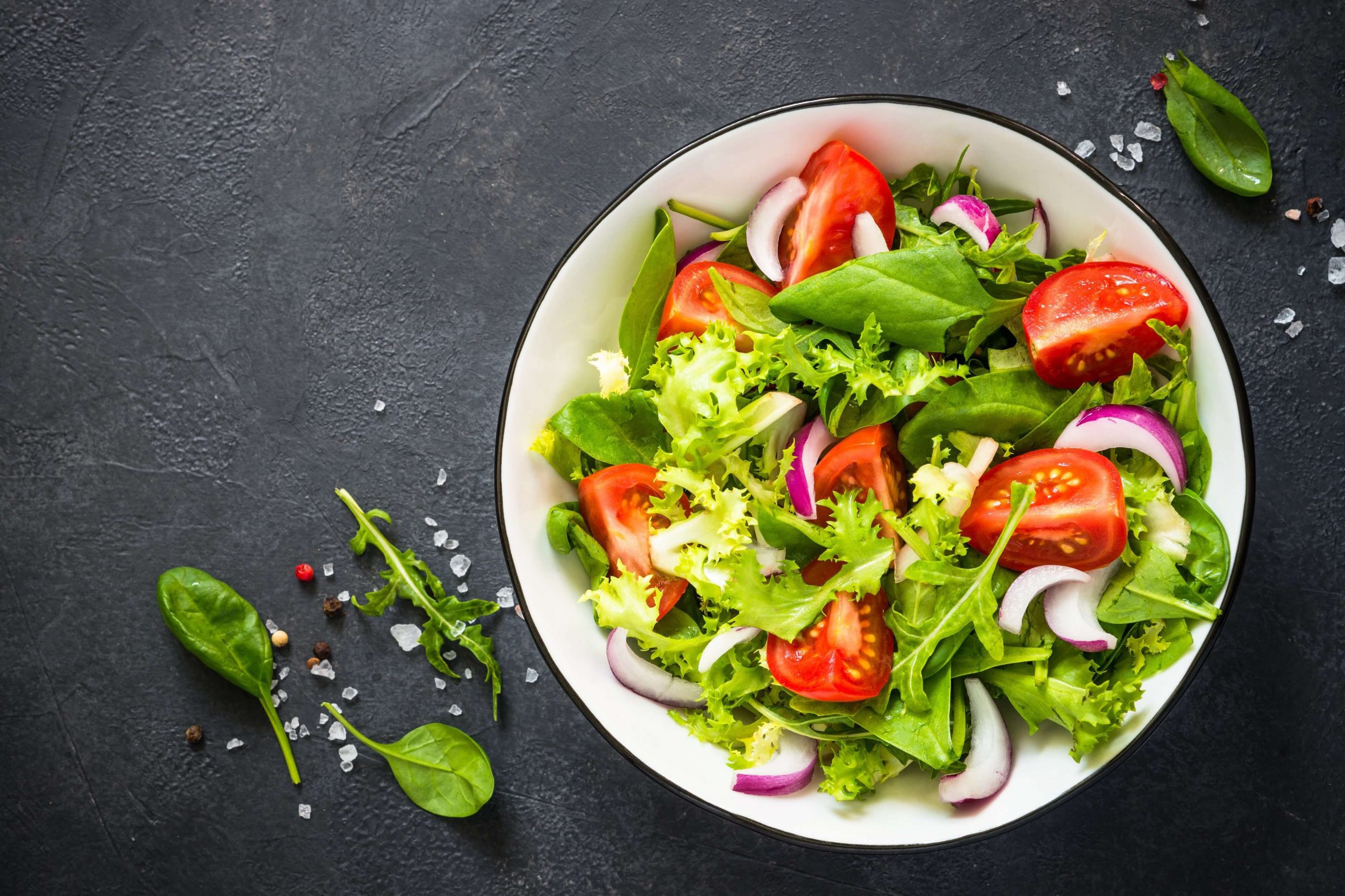 Salade verte accompagne d'oignons, de tomates et autres produits saisoniers